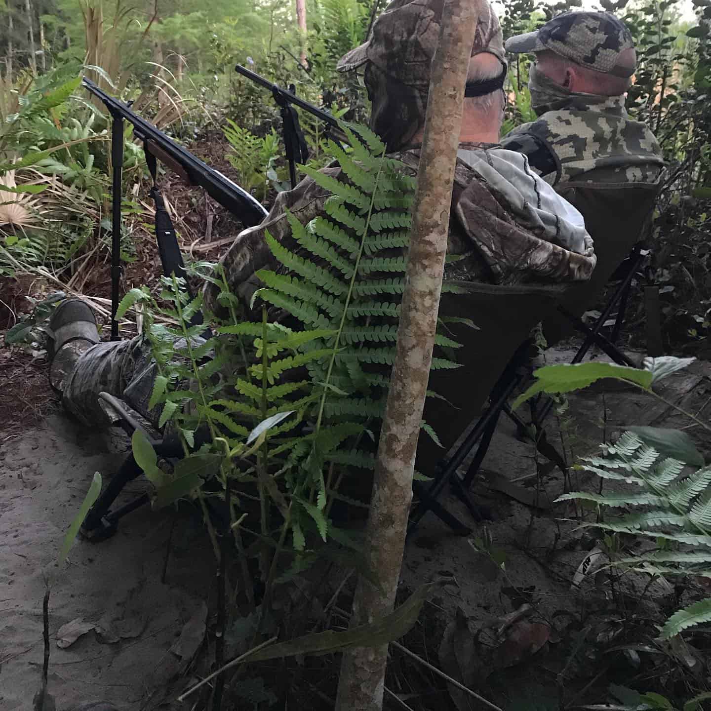 Two hunters in camouflage gear sitting in the Florida wilderness during a guided hunting trip with Salt River Outfitters in Crystal River, FL